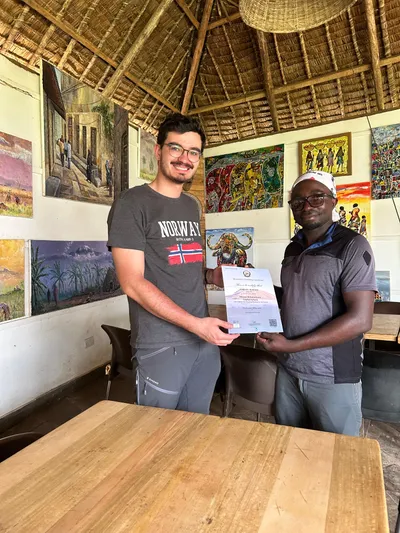 A climber receiving their Kilimanjaro summit certificate