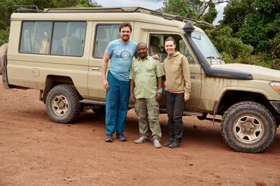 Our guide with travelers beside the safari Land Cruiser